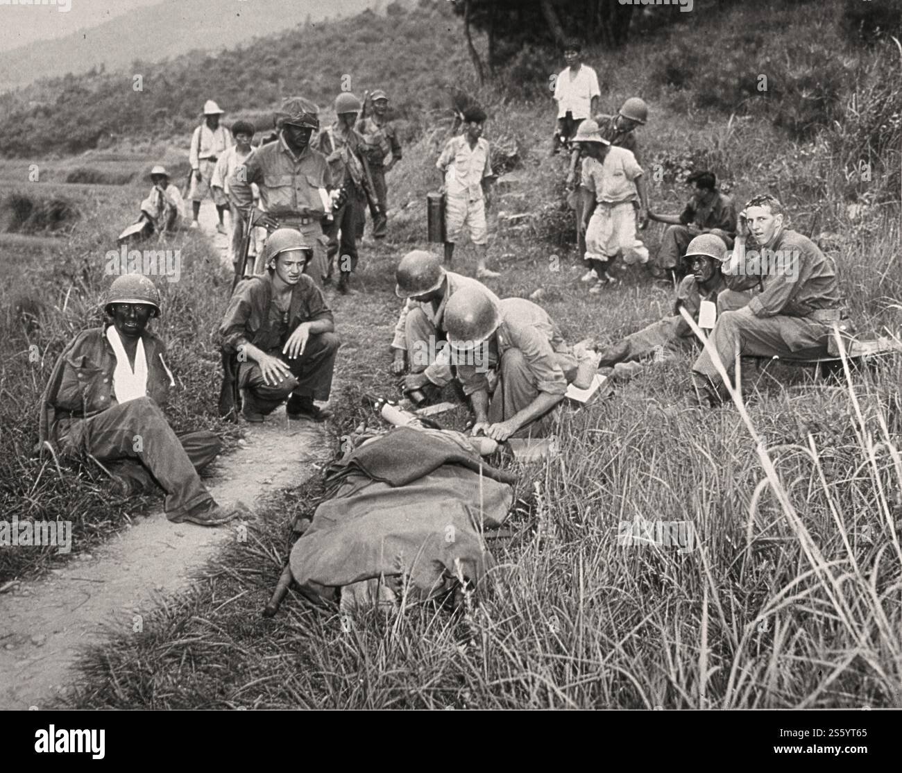 Medicina in tempo di guerra - medico che amministra il pronto soccorso ai feriti - documento storico, fotografo sconosciuto. Foto Stock