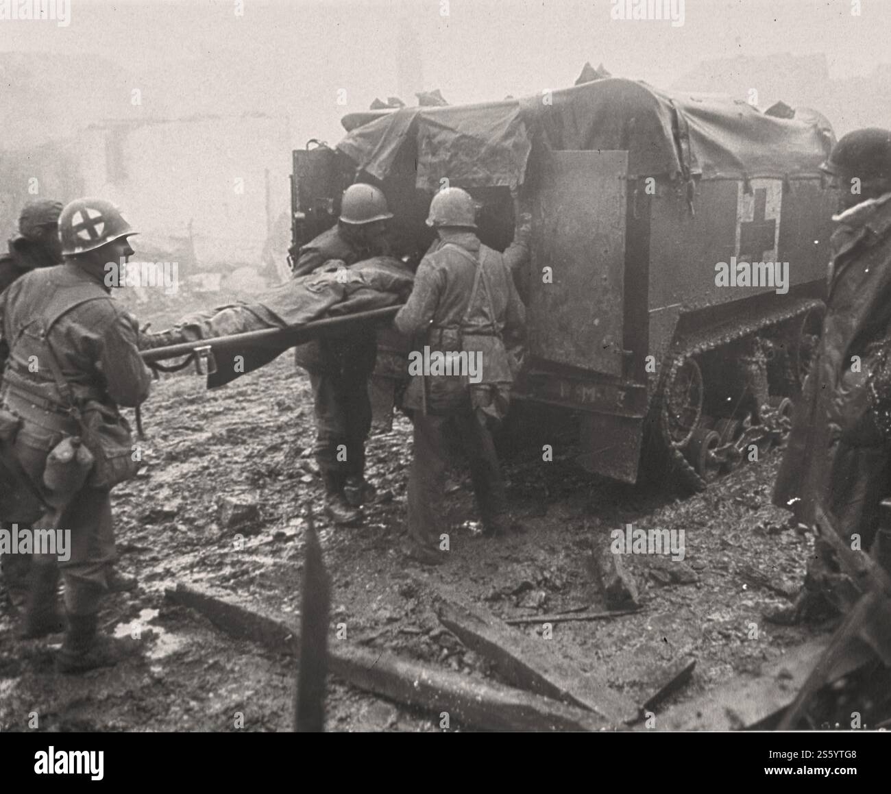 Medicina in tempo di guerra - il soldato americano ferito viene caricato in Un Medic Half-Track - seconda guerra mondiale - documento storico, fotografo sconosciuto. Foto Stock
