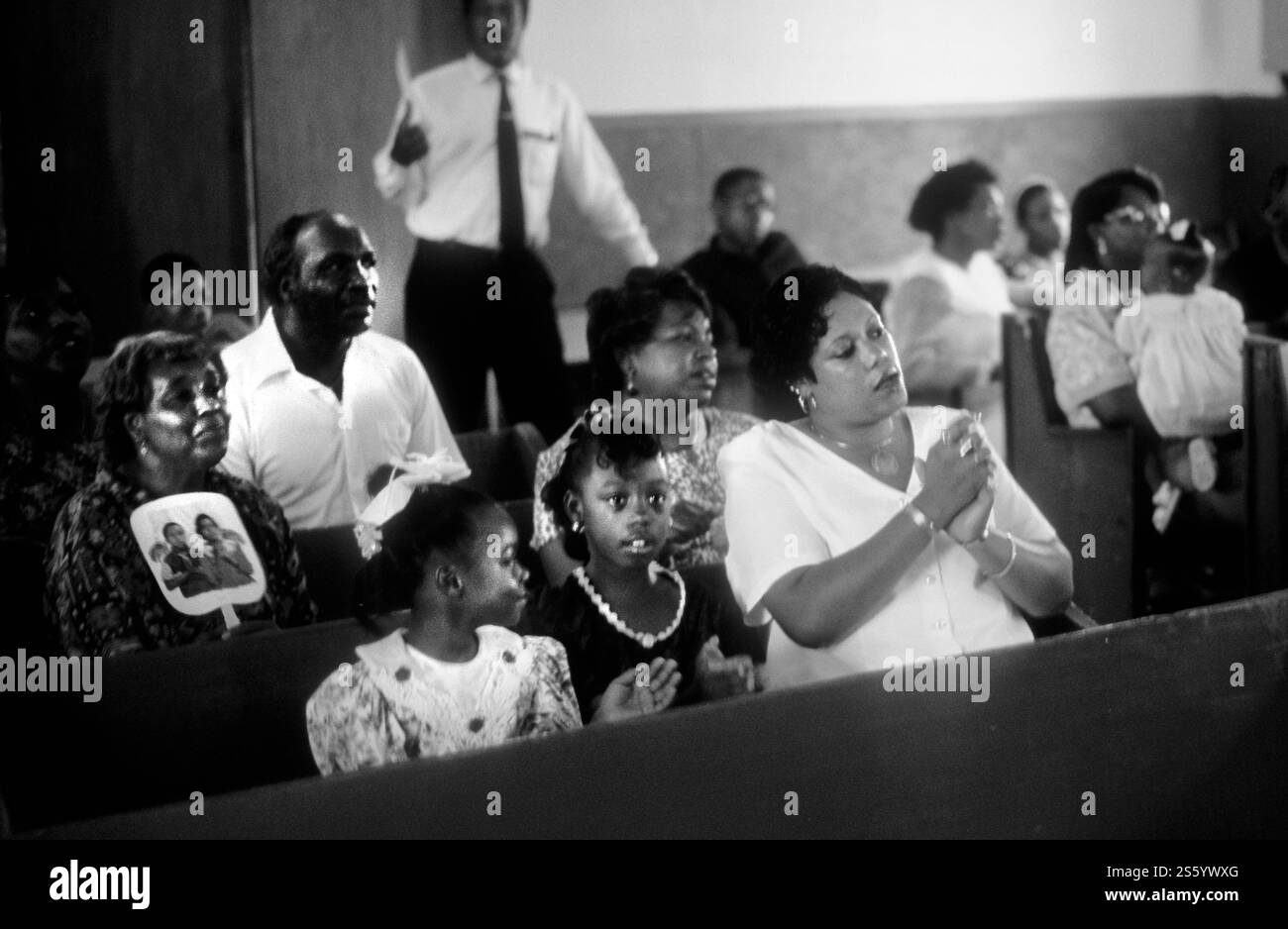 Riunione comunitaria di una congregazione ecclesiastica con diversi partecipanti impegnati in culto e preghiera Foto Stock