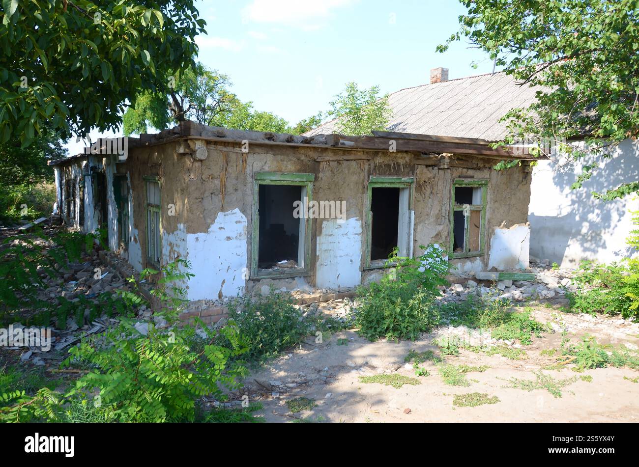 L'edificio industriale è crollato di giorno. Scena del disastro piena di detriti, mattoni rotti e case residenziali danneggiate. Concetto di azione bellica dopo la morte Foto Stock