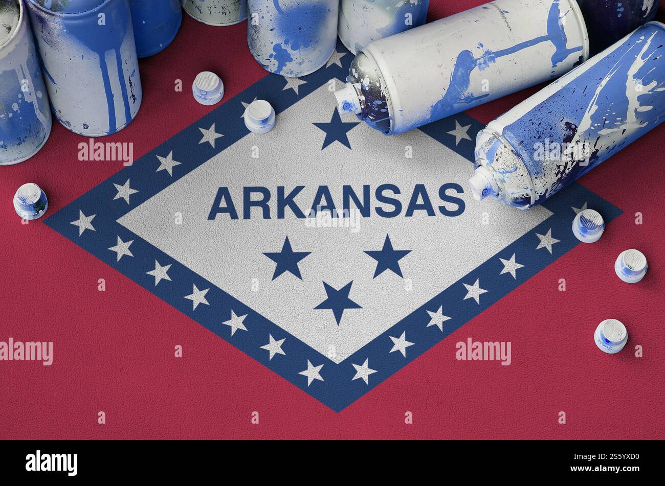 Arkansas bandiera dello stato degli Stati Uniti e pochi spray aerosol usati per la pittura di graffiti. Concetto di cultura dell'arte di strada, problemi di vandalismo. Bandiera dello stato dell'Arkansas Foto Stock
