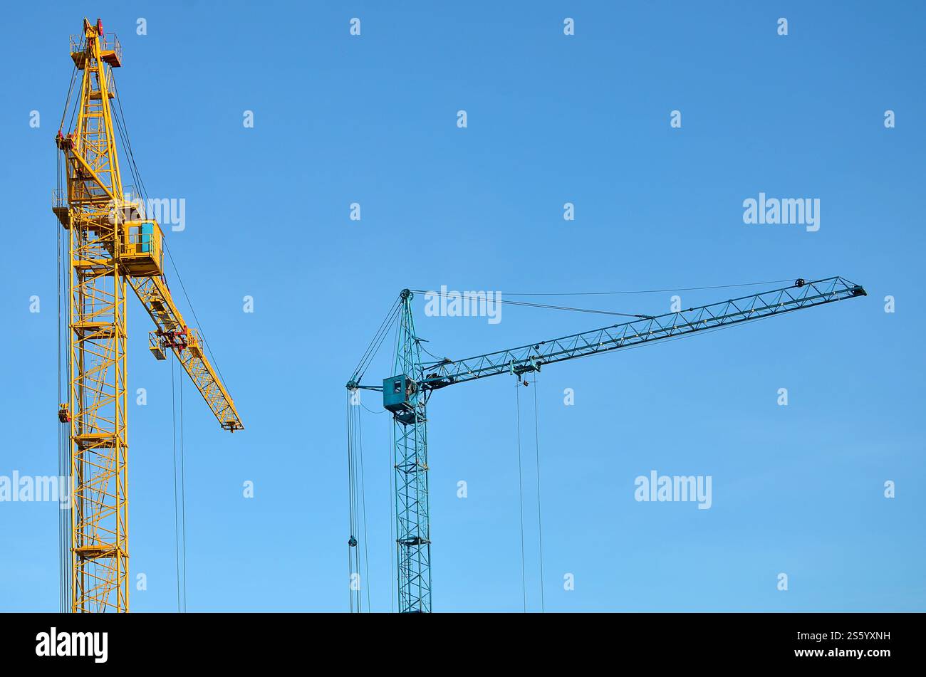 Sfondo industriale astratto con gru a torre da costruzione su un cielo blu chiaro. Cantiere. Edificio in fase di costruzione con Foto Stock