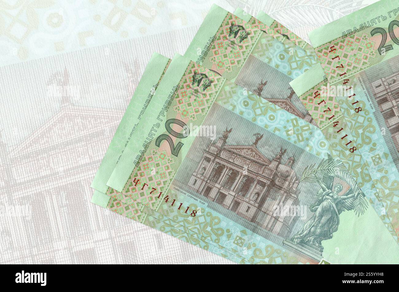 20 banconote ucraine in hryvnias si trovano in una pila sullo sfondo di grandi banconote semitrasparenti. Presentazione astratta della moneta nazionale. Affari Foto Stock