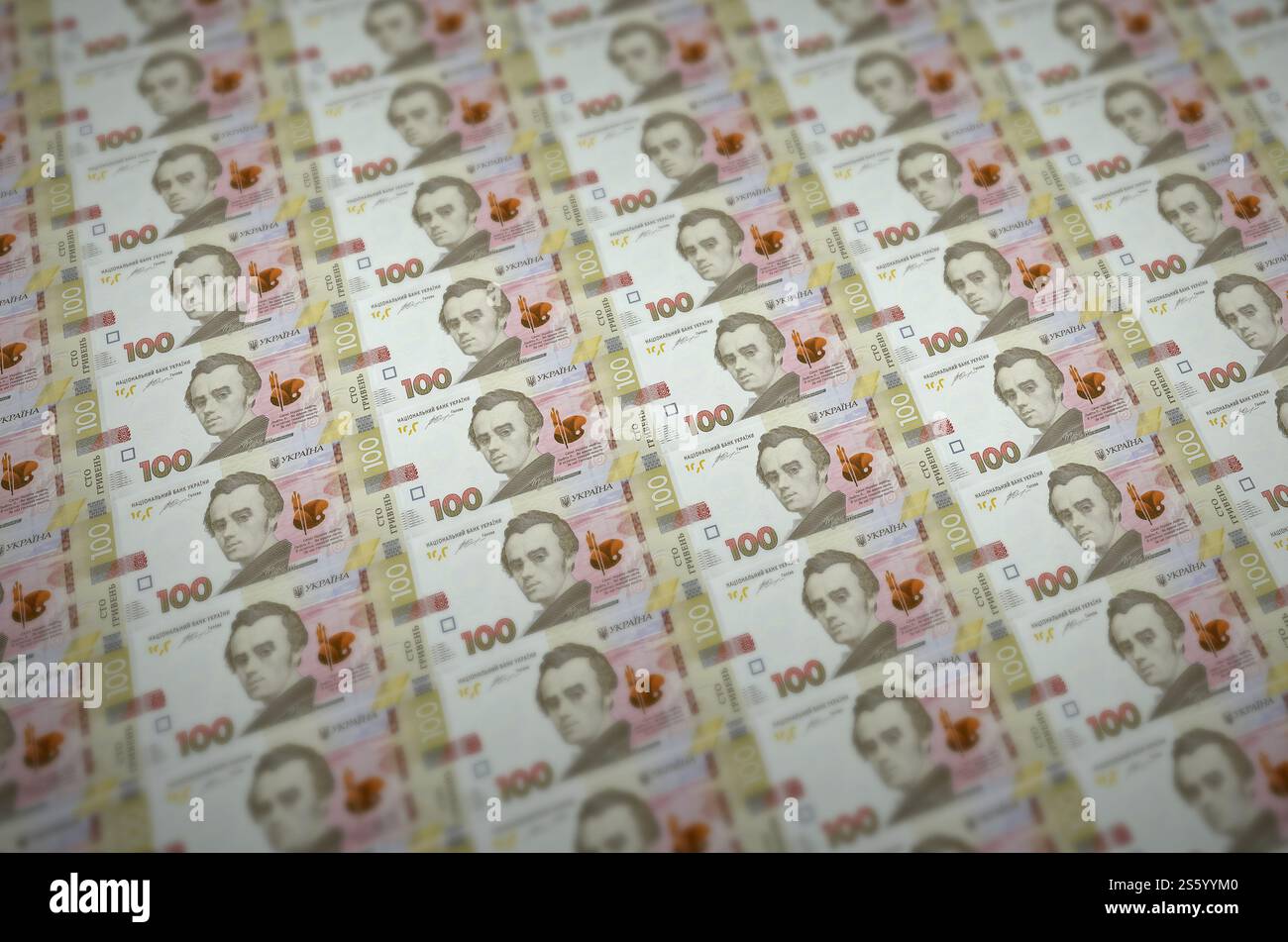 100 banconote ucraine di hryvnias stampate in un trasportatore di produzione di denaro illegale. Collage di molte banconote false. Concetto di lavoro di massa dei contraffattori. 100 Foto Stock