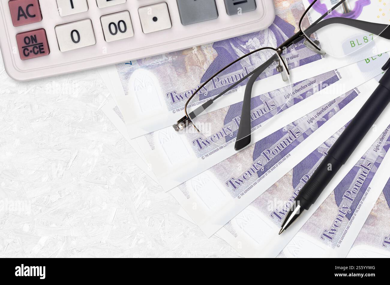20 sterline inglesi ventilatore e calcolatrice con occhiali e penna. Concetto di stagione del prestito aziendale o del pagamento delle imposte. Pianificazione finanziaria. 20 sterline britanniche Foto Stock