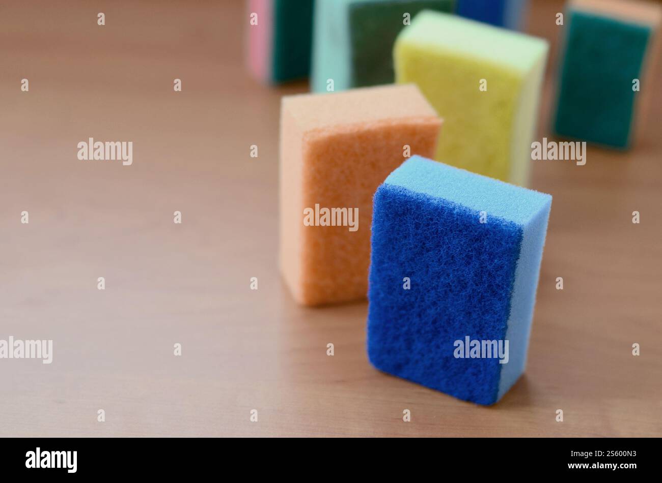 Un paio di spugne cucina giacciono su una cucina in legno il ripiano del bancone. Gli oggetti colorati per il lavaggio di stoviglie e pulizia in casa sono pronto per l'uso Foto Stock