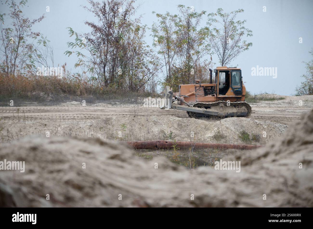 Aggregato da cava con macchinari per impieghi gravosi nel settore delle costruzioni. Escavatore pala Caterpillar con retroescavatore per la cava del cantiere. Foto Stock