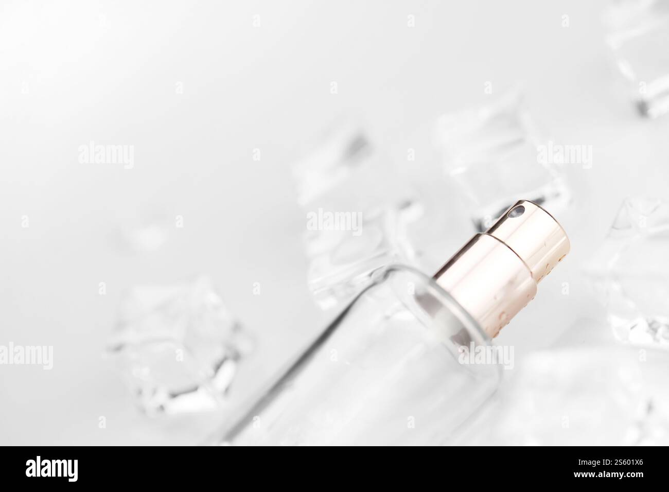 Bottiglia di profumo femminile, fotografia oggettiva della bottiglia di profumo in cubetti di ghiaccio e acqua. vista dall'alto. foto del prodotto, concetto di freschezza e aroma. Foto Stock