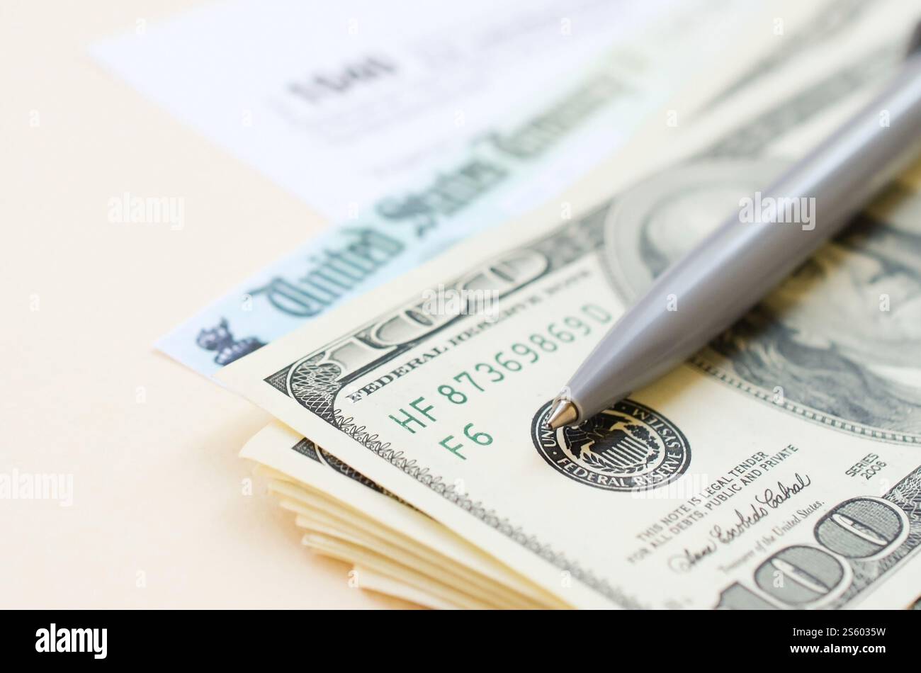 1040 modulo di dichiarazione dei redditi individuali con assegno di rimborso e banconote da cento dollari su sfondo beige. Concetto del periodo fiscale. Pianificazione finanziaria e. Foto Stock