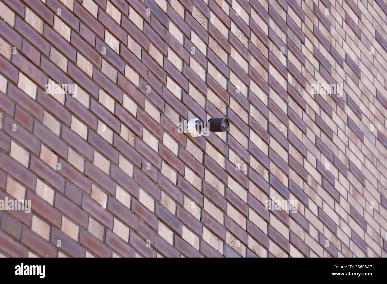 Telecamera di sicurezza CCTV wireless nera per la sorveglianza dell'area posizionata su una parete di mattoni. Le telecamere di sorveglianza sono tecnologie moderne per prevenire i ladri e. Foto Stock