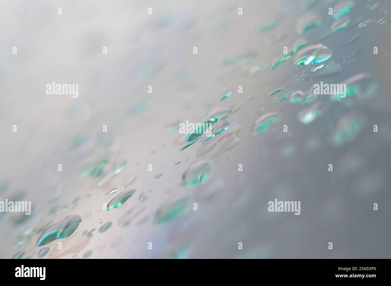 Acqua di piccole gocce di pioggia sul vetro blu nella macro. Natura astratta sfondo Foto Stock