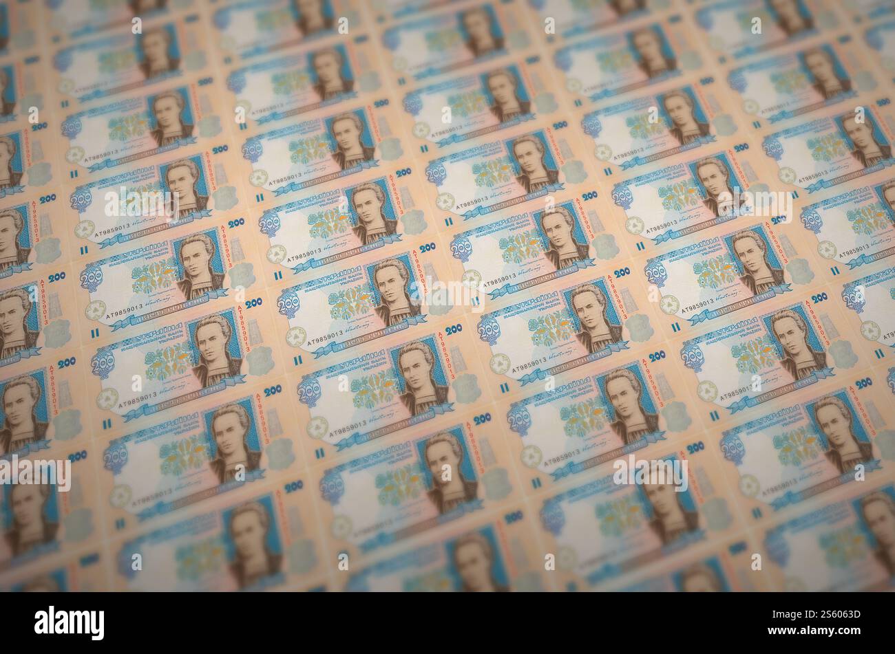 200 banconote ucraine di hryvnias stampate in un trasportatore di produzione di denaro illegale. Collage di molte banconote false. Concetto di lavoro di massa dei contraffattori. 200 Foto Stock
