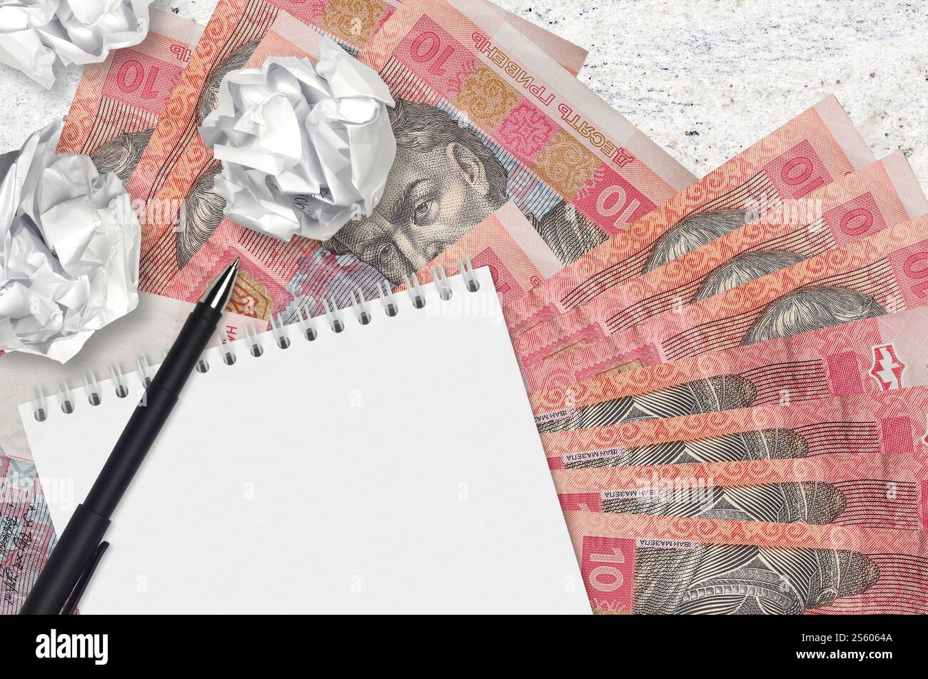 10 hryvnias ucraine banconote e palle di carta stropicciata con blocco note. Idee cattive o meno di concetto di ispirazione. Alla ricerca di idee per l'investimento. 10 Foto Stock
