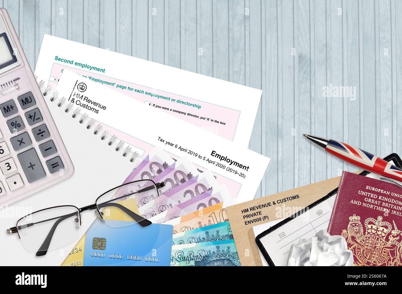 Modulo fiscale inglese sa102 l'impiego da parte di HM revenue and Customs si trova sul tavolo con gli articoli per ufficio. Documentazione HMRC e procedura di pagamento delle imposte nel Regno Unito Foto Stock