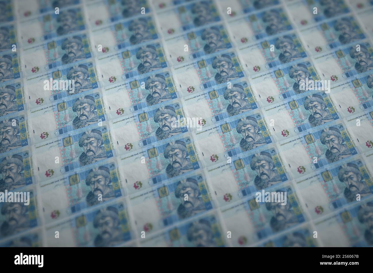 5 banconote ucraine di hryvnias stampate in un trasportatore di produzione di denaro illegale. Collage di molte banconote false. Concetto di lavoro di massa dei contraffattori. 5 Foto Stock