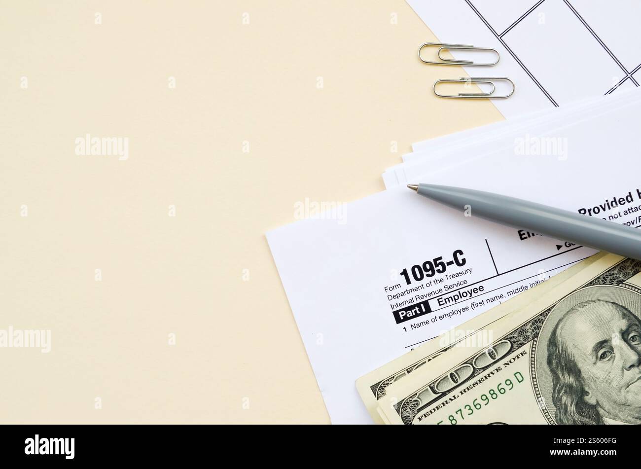 Modulo IRS 1095-C datore di lavoro-fornito offerta di assicurazione sanitaria e copertura tassa in bianco giace con penna e molte centinaia di banconote di dollari sulla pagina del calendario. Tassa Foto Stock