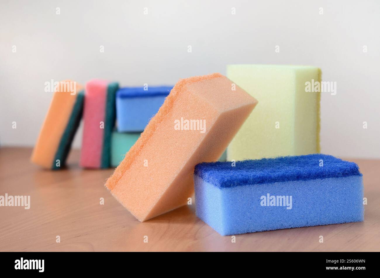 Un paio di spugne cucina giacciono su una cucina in legno il ripiano del bancone. Gli oggetti colorati per il lavaggio di stoviglie e pulizia in casa sono pronto per l'uso Foto Stock