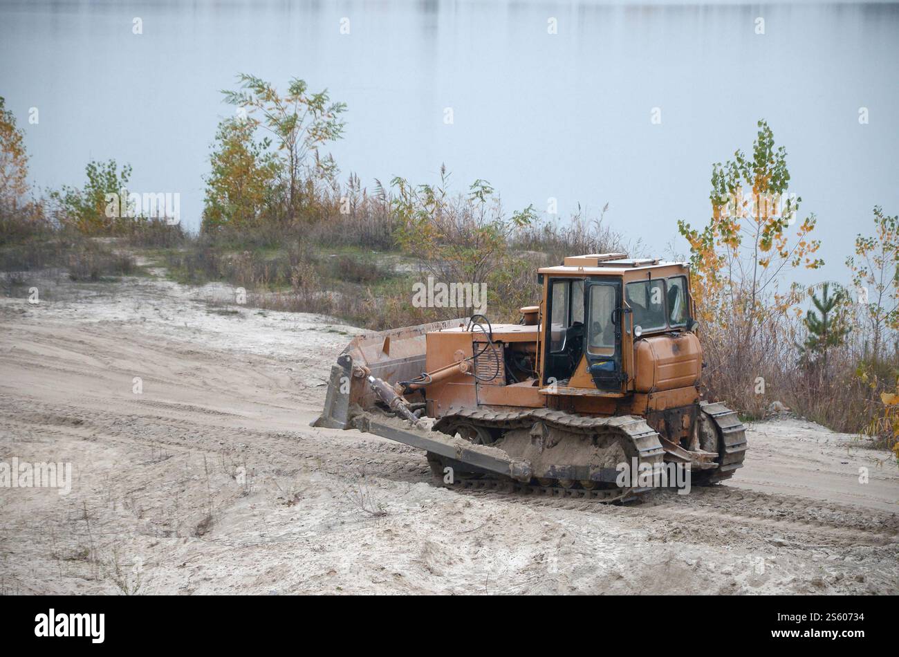 Aggregato da cava con macchinari per impieghi gravosi nel settore delle costruzioni. Escavatore pala Caterpillar con retroescavatore per la cava del cantiere. Foto Stock