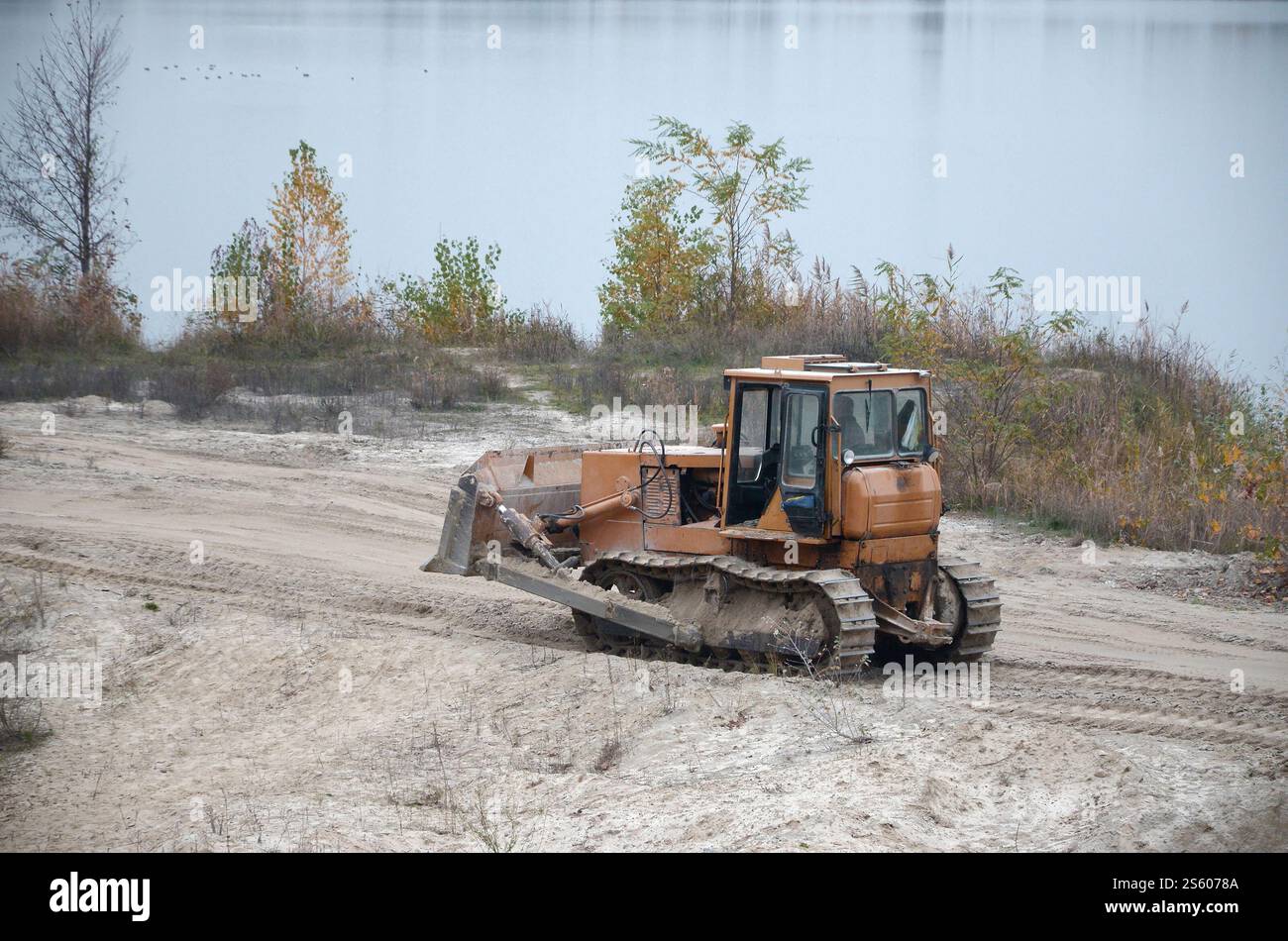 Aggregato da cava con macchinari per impieghi gravosi nel settore delle costruzioni. Escavatore pala Caterpillar con retroescavatore per la cava del cantiere. Foto Stock