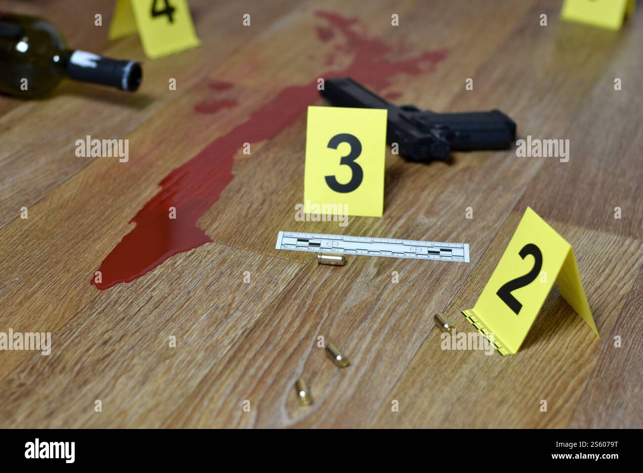 Concetto di omicidio - pistola con bottiglia di sangue e vino sul pavimento di legno da vicino. Indicatori delle prove investigative sulla scena del crimine. Concetto di omicidio: Pistola col sangue Foto Stock