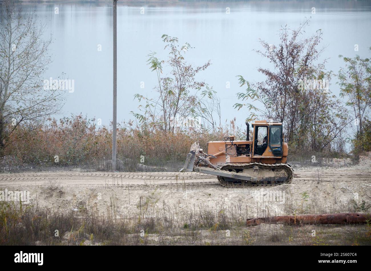 Aggregato da cava con macchinari per impieghi gravosi nel settore delle costruzioni. Escavatore pala Caterpillar con retroescavatore per la cava del cantiere. Foto Stock