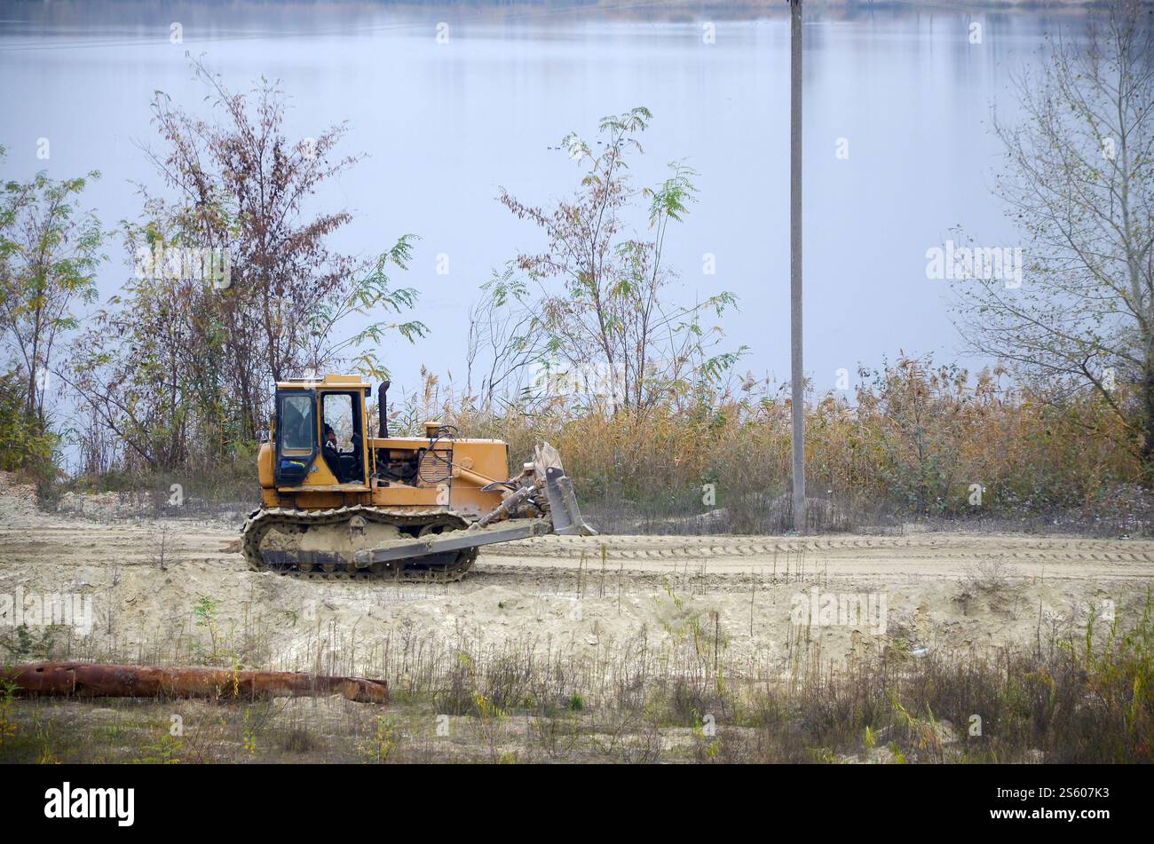 Aggregato da cava con macchinari per impieghi gravosi nel settore delle costruzioni. Escavatore pala Caterpillar con retroescavatore per la cava del cantiere. Foto Stock