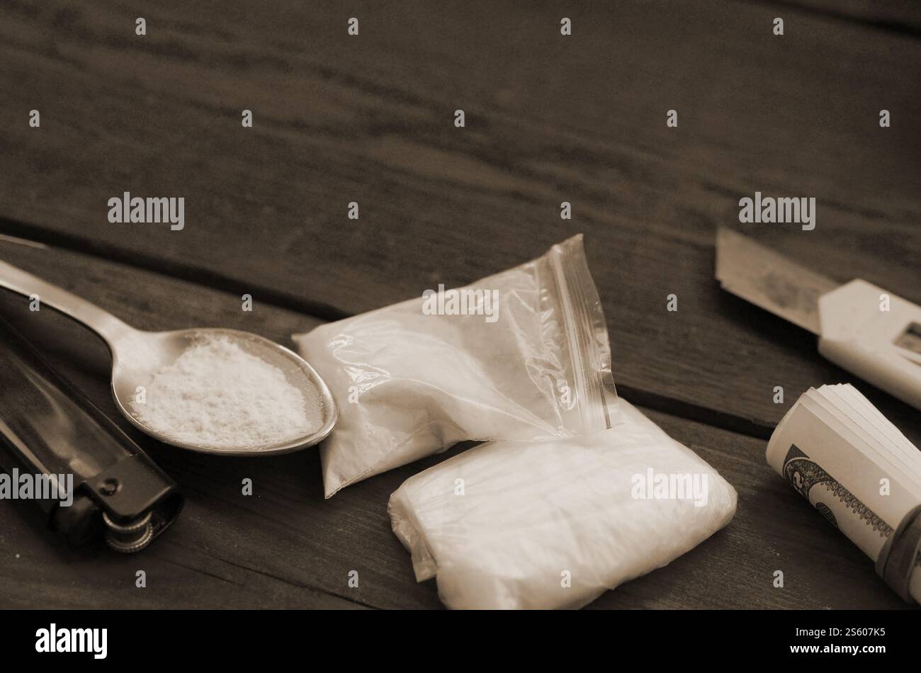 Roba di spacciatori. Coltello di carta più leggero e cucchiaio pieno di polvere bianca su sfondo di legno. Eroina e metanfetamina che usano. Dipendenza da narcotici Foto Stock