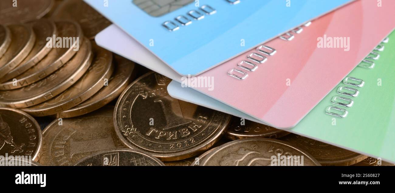 Le monete ucraine e le carte di credito colorate chiudono. Valuta dell'Ucraina. Bilanciamento del denaro e concetto di online banking. Wireless banking globale Foto Stock