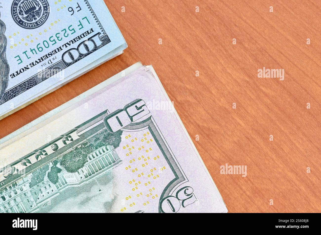 Pile di banconote da centocinquanta dollari su fondo in legno da vicino. Vista dall'alto in posizione piatta. Concetto di successo astratto o di business. Foto Stock
