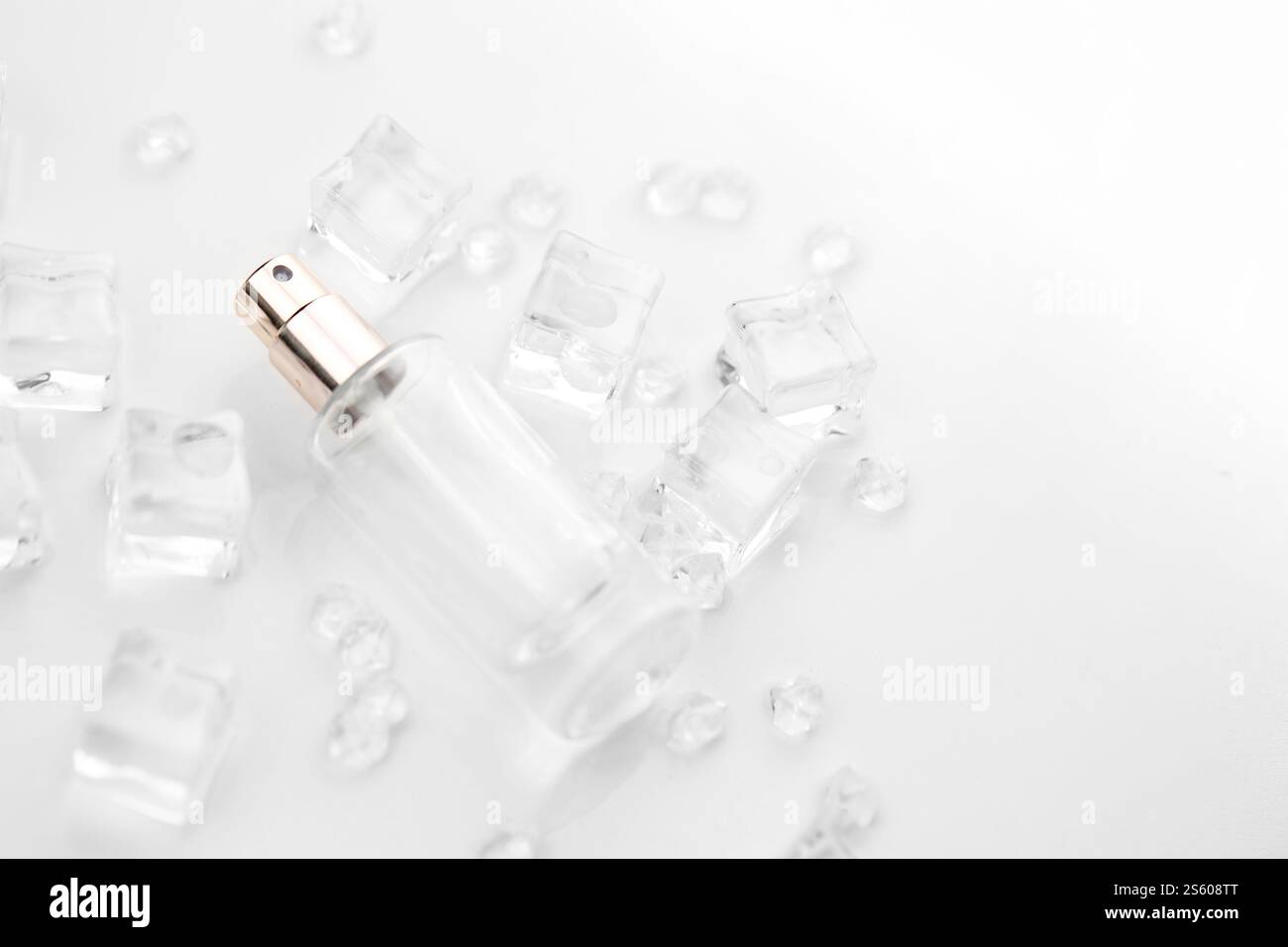 Bottiglia di profumo femminile, fotografia oggettiva della bottiglia di profumo in cubetti di ghiaccio e acqua. vista dall'alto. foto del prodotto, concetto di freschezza e aroma. Foto Stock