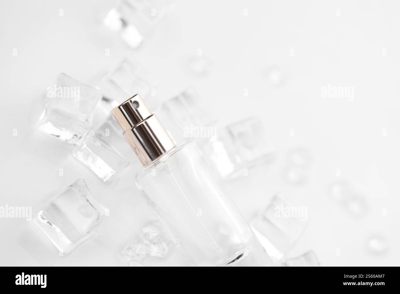 Bottiglia di profumo femminile, fotografia oggettiva della bottiglia di profumo in cubetti di ghiaccio e acqua. vista dall'alto. foto del prodotto, concetto di freschezza e aroma. Foto Stock