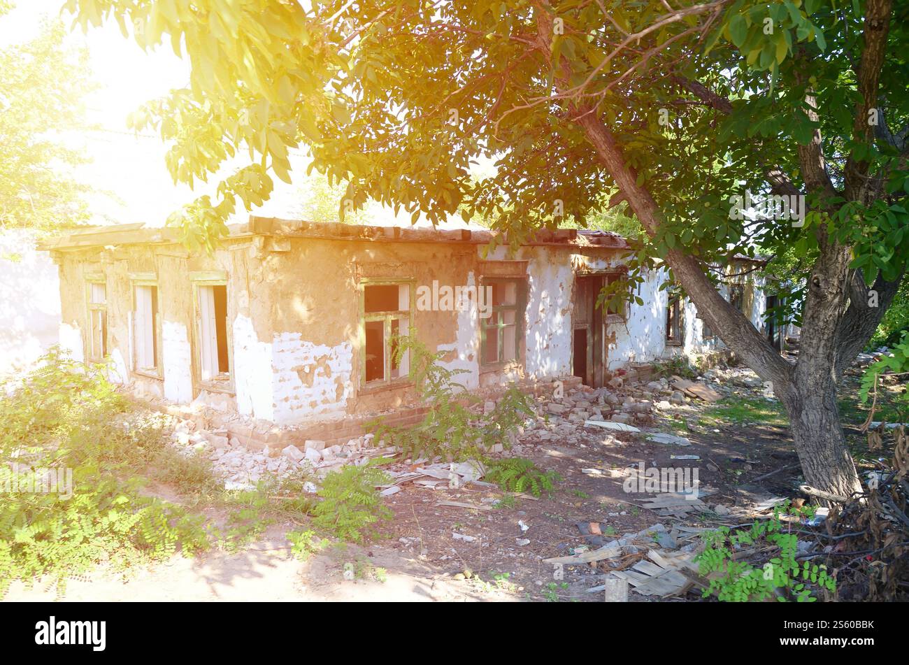 L'edificio industriale è crollato di giorno. Scena del disastro piena di detriti, mattoni rotti e case residenziali danneggiate. Concetto di azione bellica dopo la morte Foto Stock