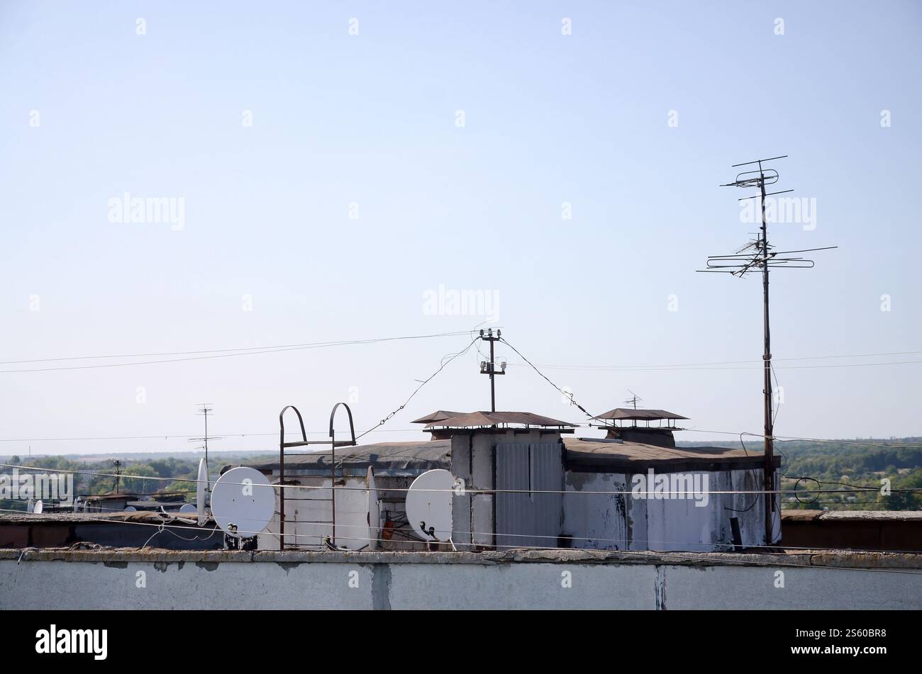 Parabole satellitari bianche con due convertitori montati sulla parete in cemento sul tetto dell'edificio residenziale. Pubblicità televisiva satellitare. Satellite bianco Foto Stock