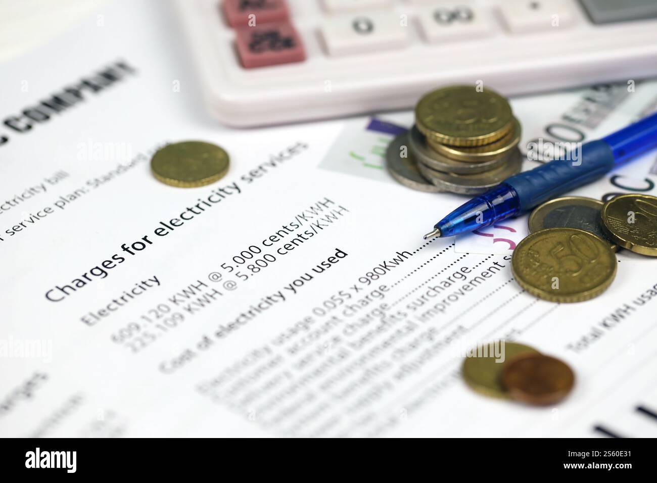 Calcolatrice e bollette Euro con penna sulla bolletta europea dell'elettricità. Concetto di risparmio economico utilizzando lampadine a LED a risparmio energetico e bolletta elettrica Foto Stock