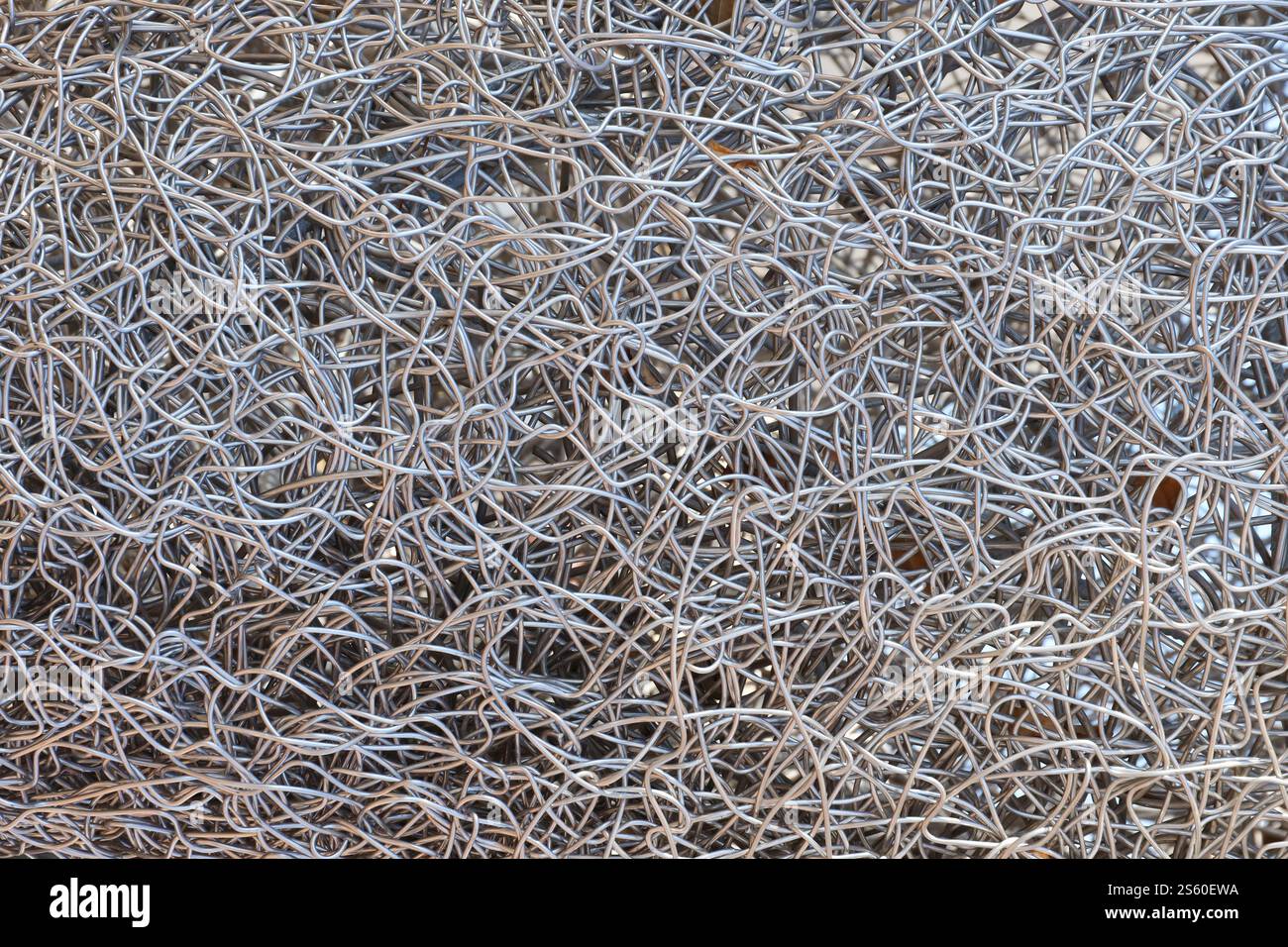 Sfondo con struttura metallica a schermo intero. Rottami di metalli non ferrosi. Concetto di riciclaggio per la progettazione. Sfondo della trama del filo metallico completo Foto Stock