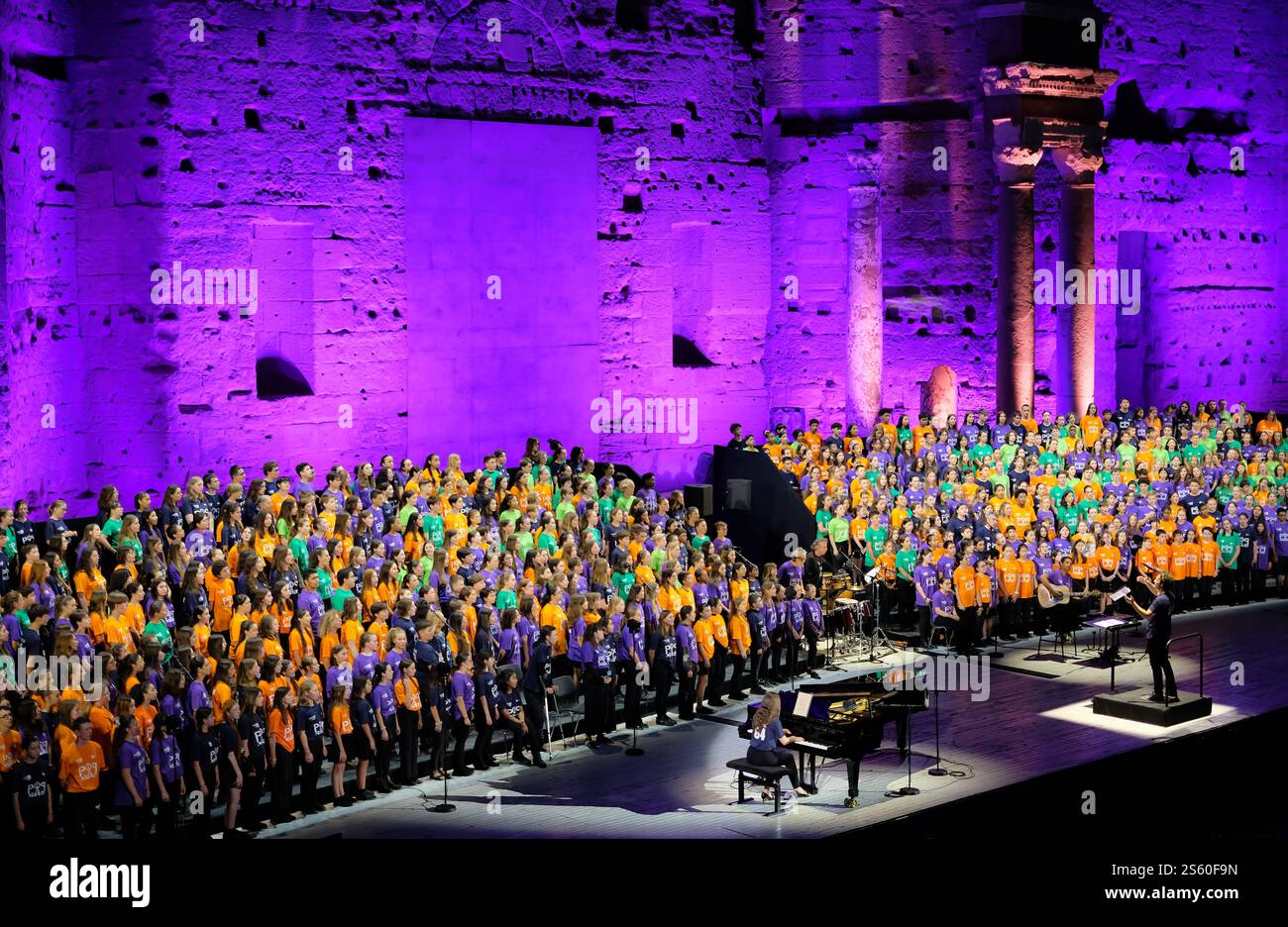 Bambini che cantano sul palco del Teatro Romano di Orange, Vaucluse, Francia. Strumenti musicali. Spettacolo serale. Foto Stock