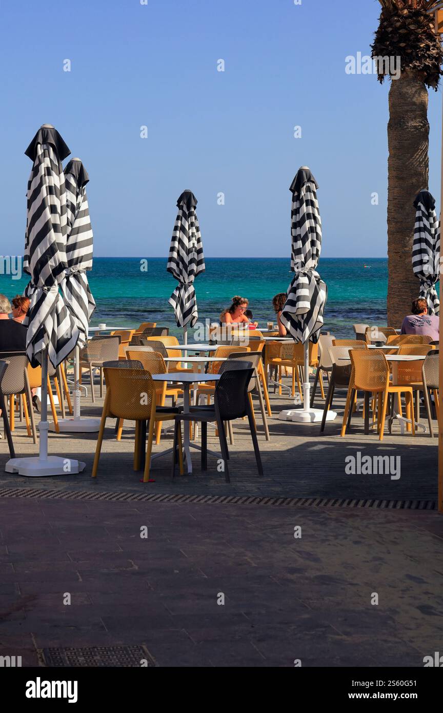 I turisti apprezzano un caffè all'aperto vicino al mare, Corralejo, Fuerteventura, Isole Canarie, Spagna, UE - dicembre 2024 Foto Stock