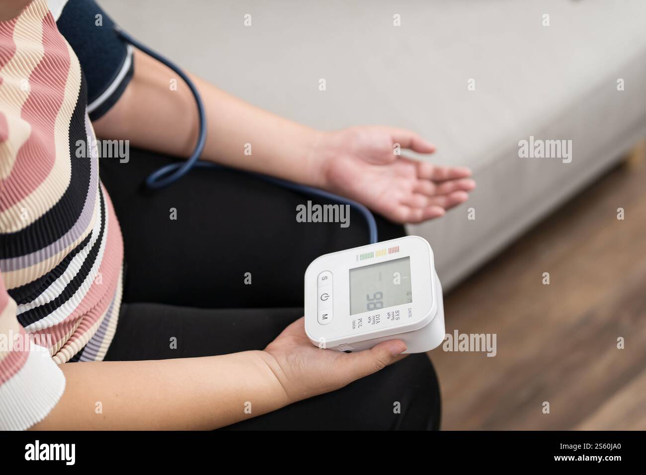 Controllo automatico della pressione sanguigna e della frequenza cardiaca da parte della donna in sovrappeso Plus size. Foto Stock