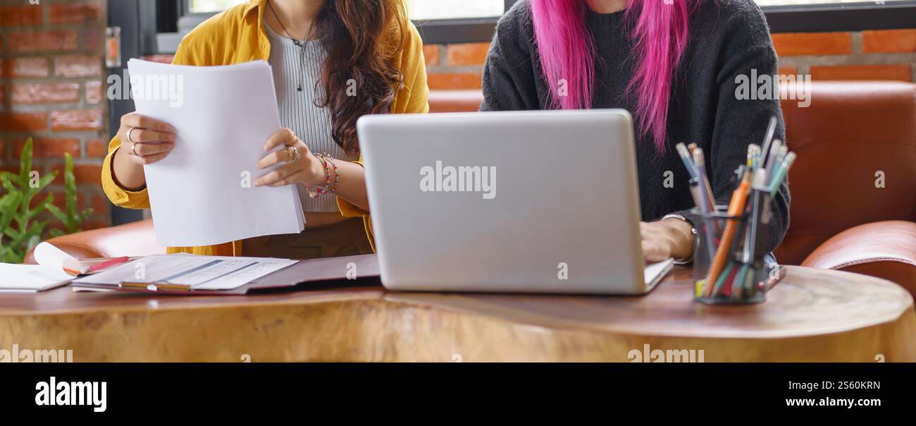 LGBTQ+ transgender uomo bellissimo autentico Specialista con capelli rosa e trans non binari che lavorano insieme Design nel team creativo del luogo di lavoro Foto Stock