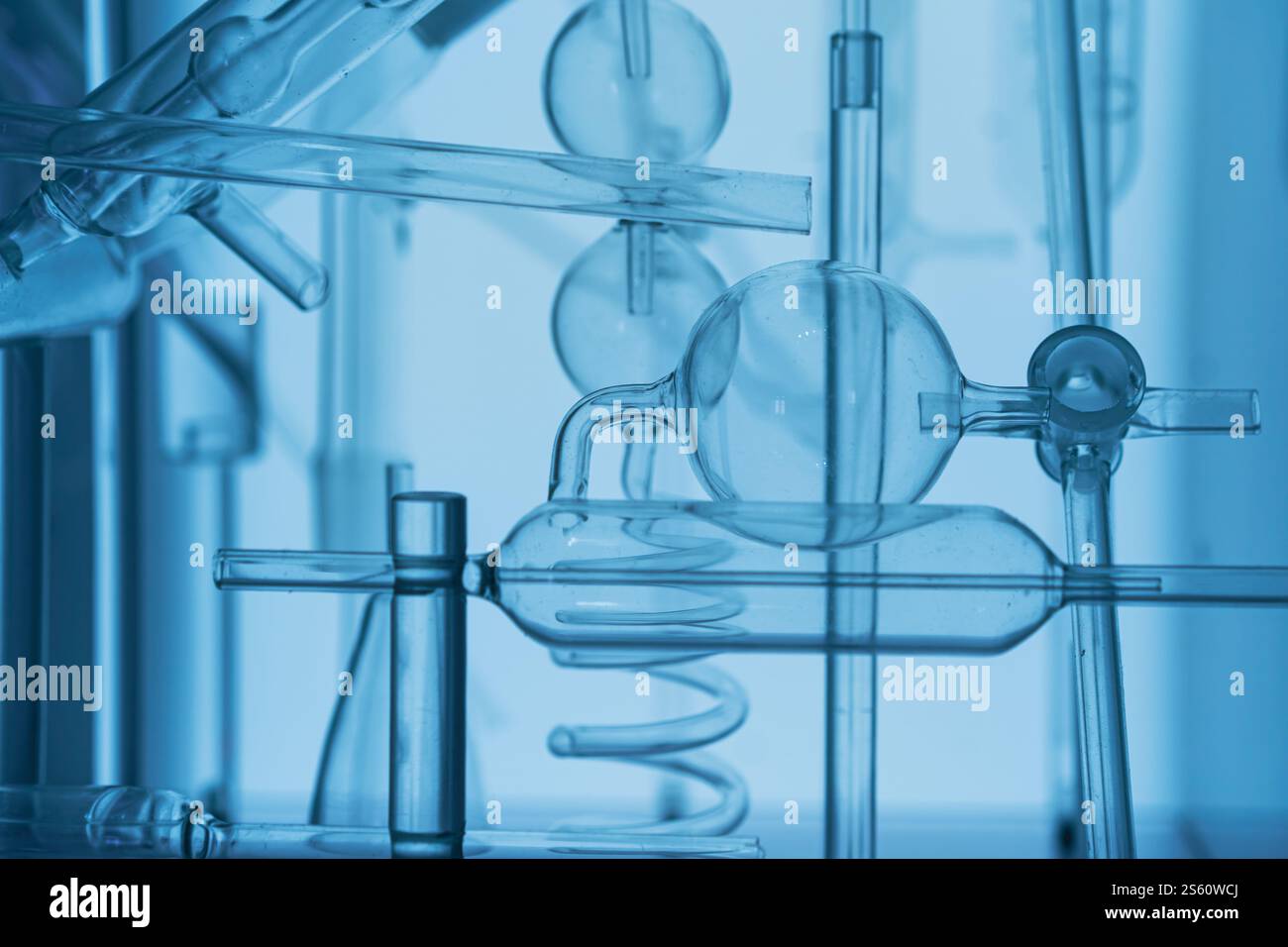 Primo piano di un apparecchio scientifico in vetro con tubi e matracci intricati in un ambiente di laboratorio Foto Stock