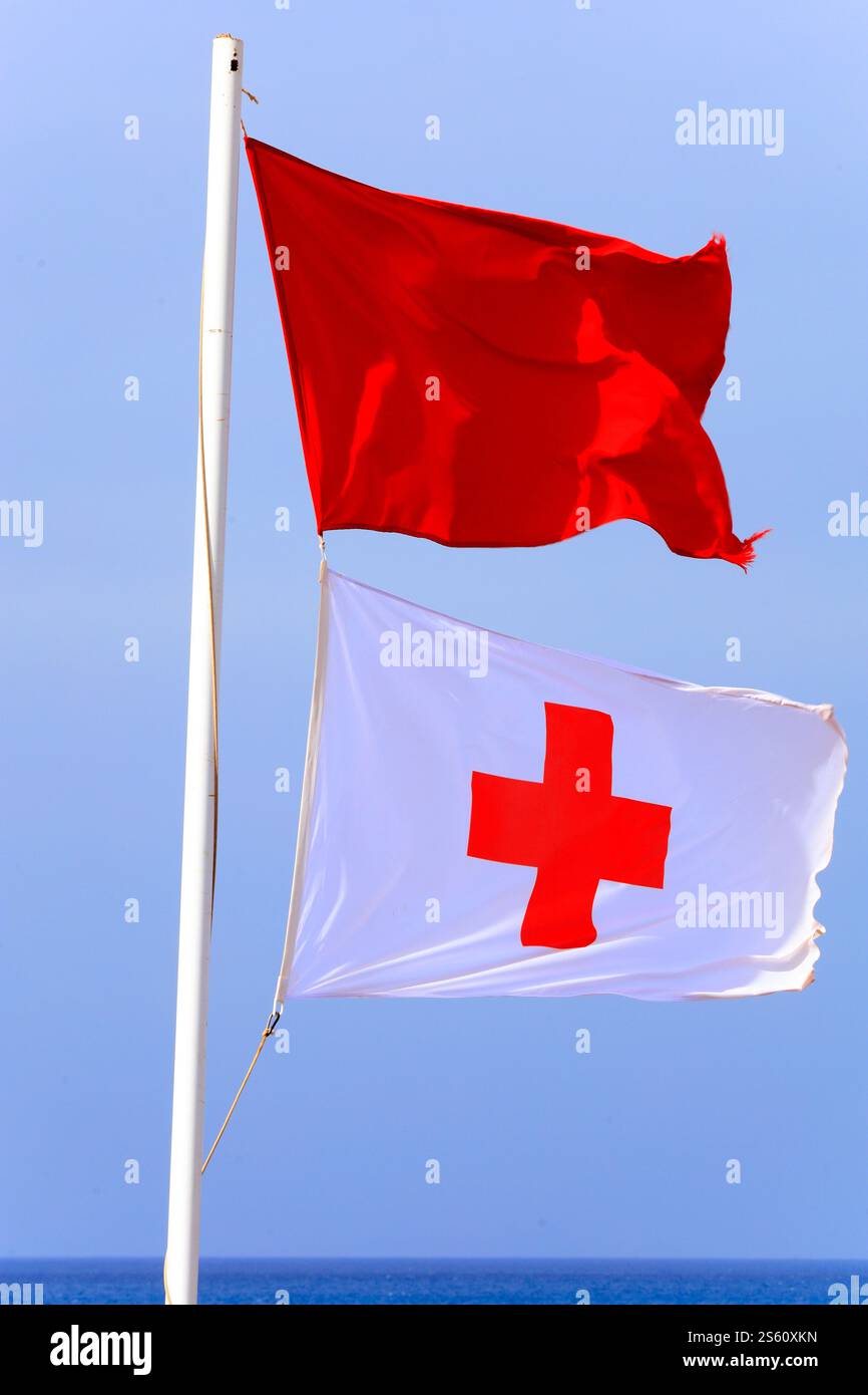 Bandiera rossa e croce rossa Cruz Roja bandiera di pronto soccorso, Playa Piedra, El Cotillo, Fuerteventura, Isole Canarie, Spagna. Foto Stock