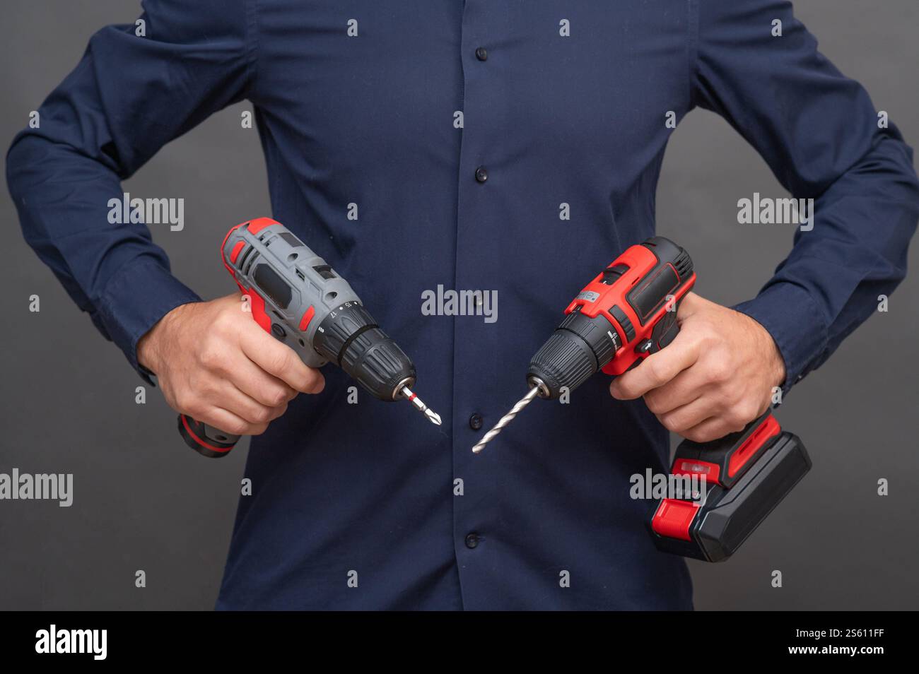 Un uomo ha due cacciaviti a batteria. Foto Stock