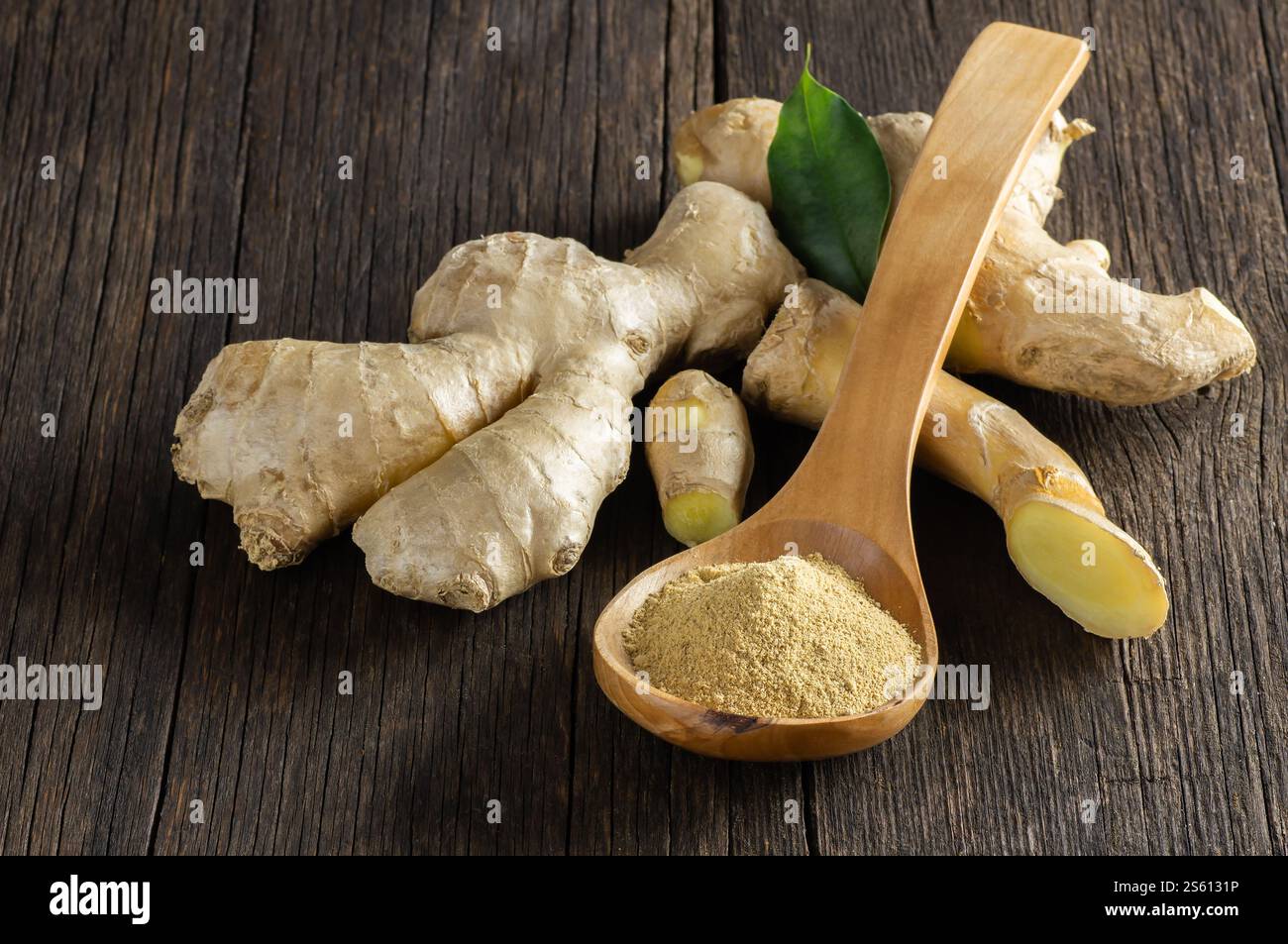 Zenzero fresco tritato e polvere di zenzero macinato in cucchiaio di legno su un tavolo rustico in legno. Cibo sano, spezie. Zingiber officinale Foto Stock