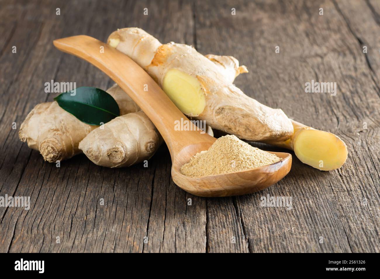 Zenzero fresco tritato e polvere di zenzero macinato in cucchiaio di legno su un tavolo rustico in legno. Cibo sano, spezie. Zingiber officinale Foto Stock