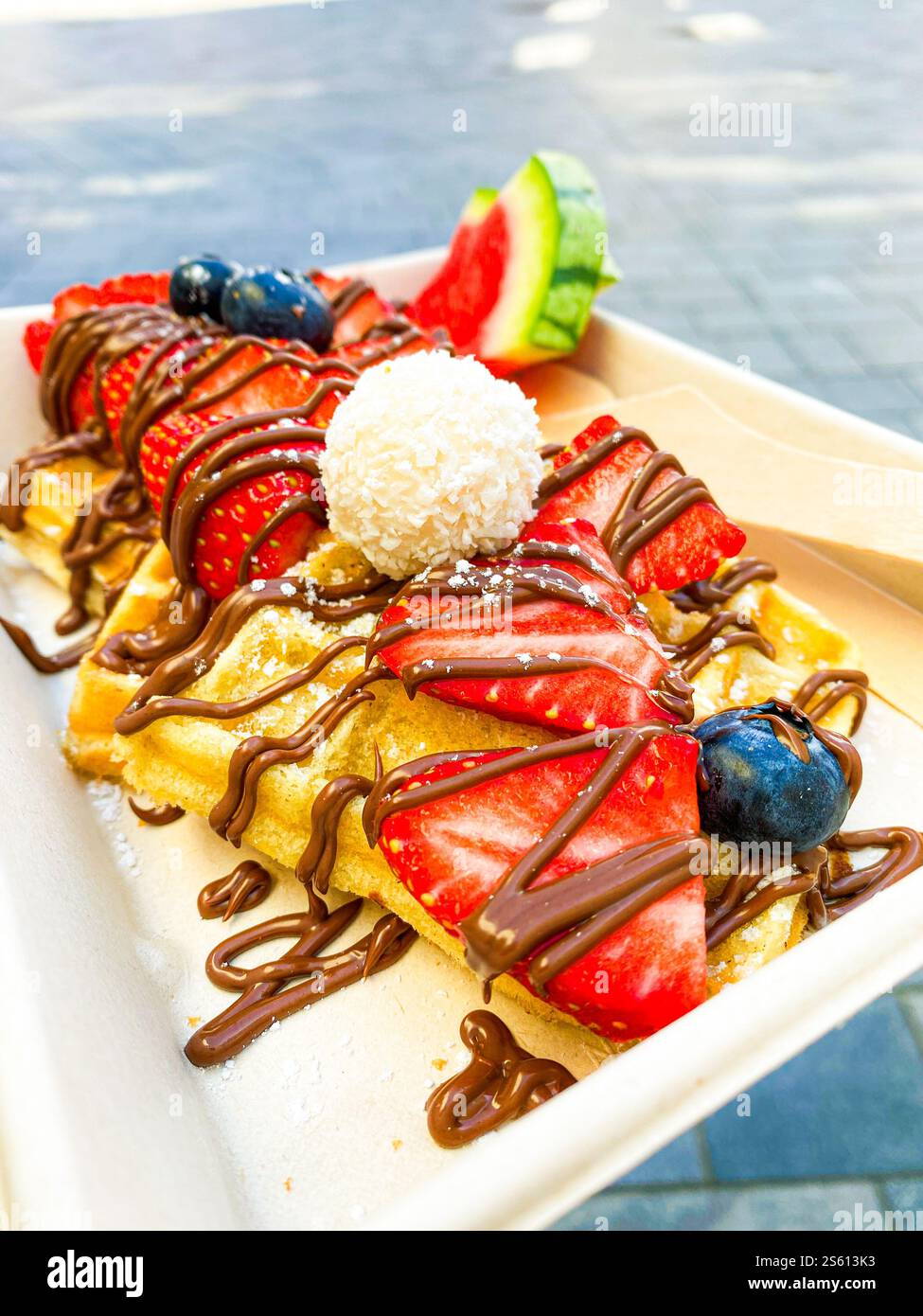 waffle con fragole e cioccolato con frutti di bosco su supporto di cartone Foto Stock