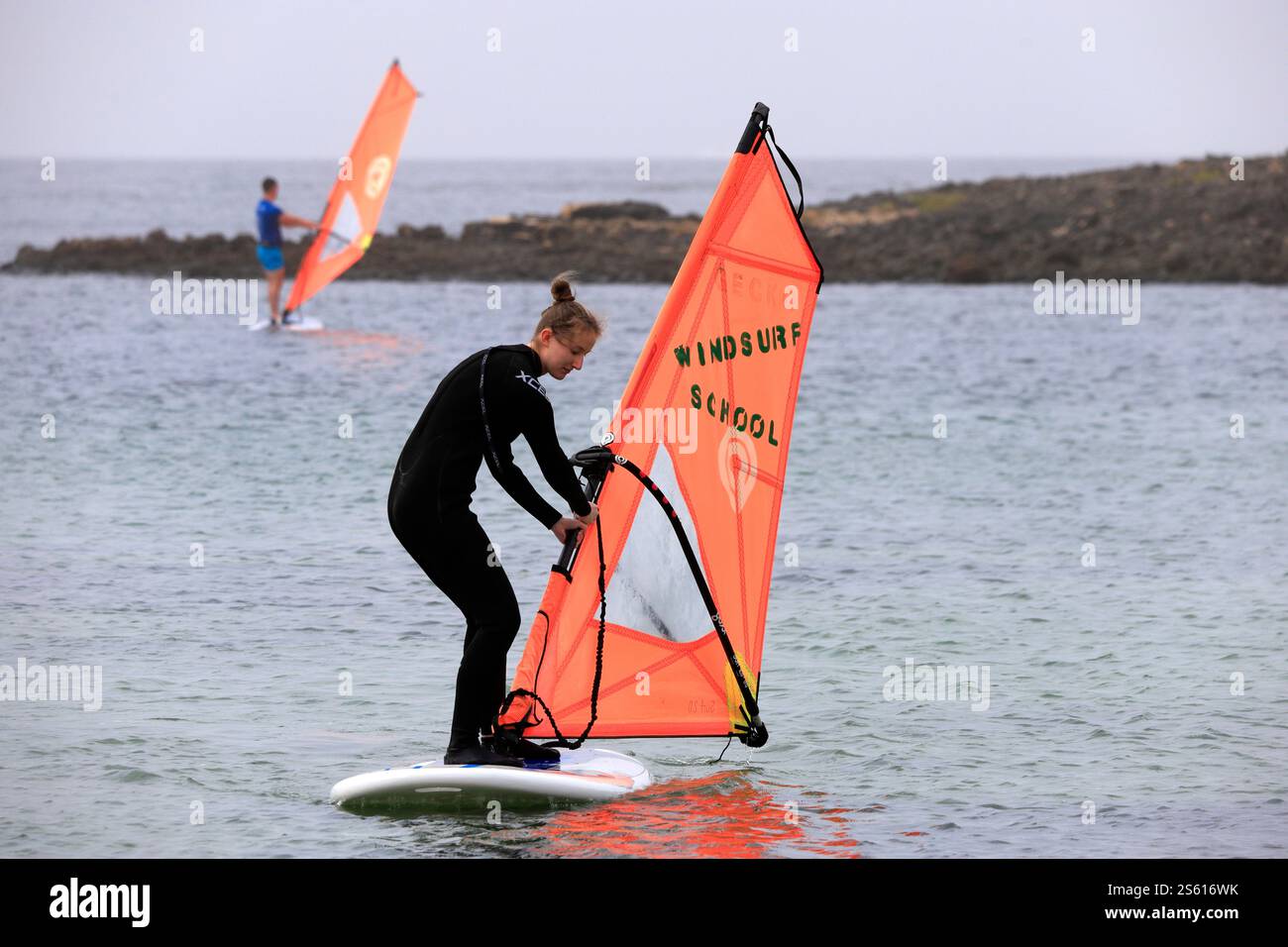 Donna che impara a praticare windsurf, scuola di windsurf, El Cotillo, Fuerteventura, Isole Canarie, Spagna. Foto Stock