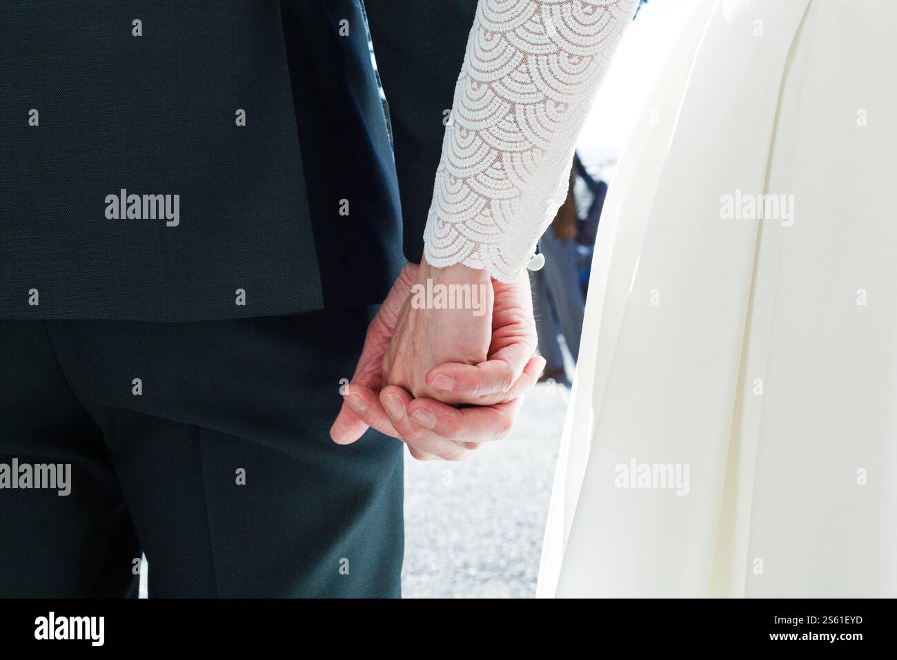 Una coppia appena sposata che si tiene per mano Foto Stock
