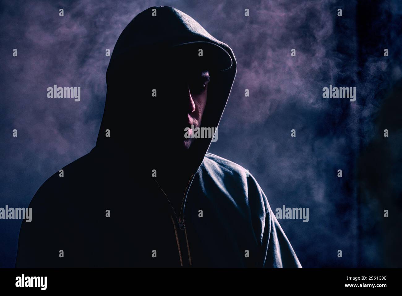 Criminale all'ombra. Spaventoso gangster sospetto con volto nascosto e felpa con cappuccio. Sagoma di sconosciuto. Crimine di gang o concetto di stalker. Hooligan. Foto Stock