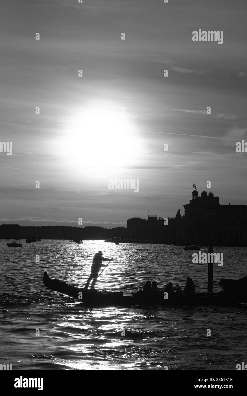 Sagome al tramonto sulla gondola a Venezia Foto Stock