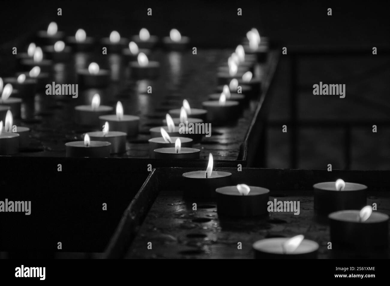 Candele in chiesa. Messa a fuoco selettiva delle candele negli angoli. Foto obsoleta. Bianco e nero. Foto Stock